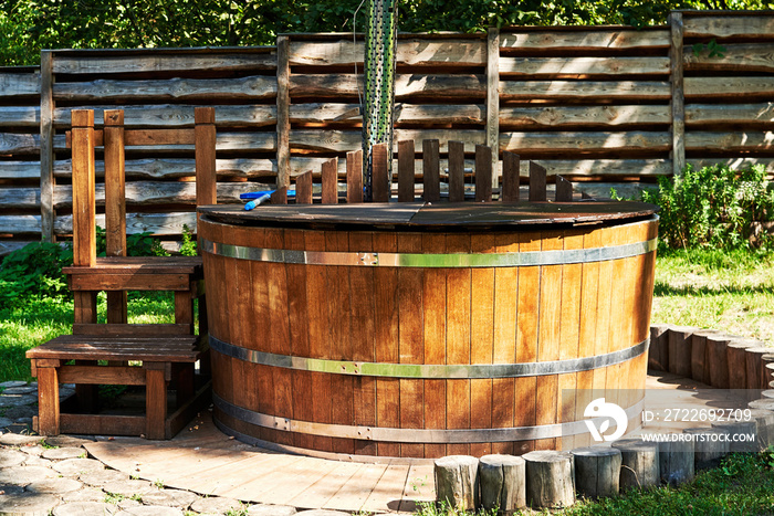 Modern wooden hot tub with stairs in garden outdoor, copy space. Wooden pool, jacuzzi, outdoor hot tub, spa