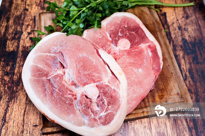 slice of fresh pork on a wooden cutting board