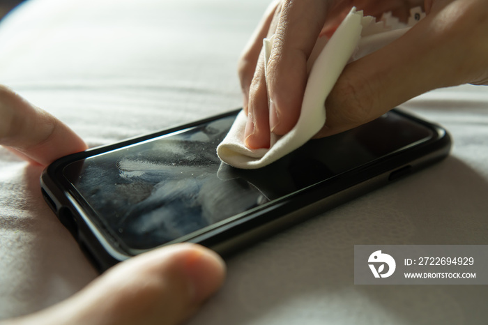 Cleaning dirty smartphone screen with microfiber cloth