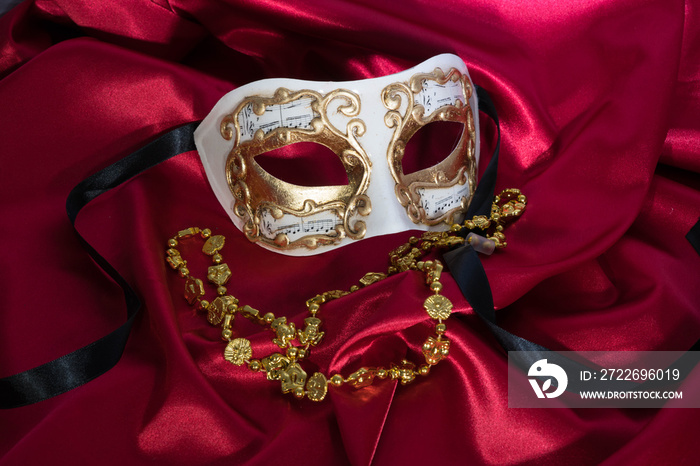 Gold and White Mask on Red Satin with Gold Mardi Gras Necklace