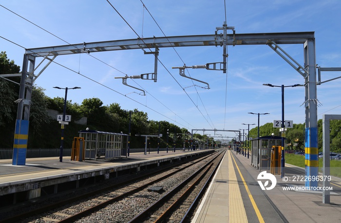 A view looking down the platform and along the train track at a British Railway Station.