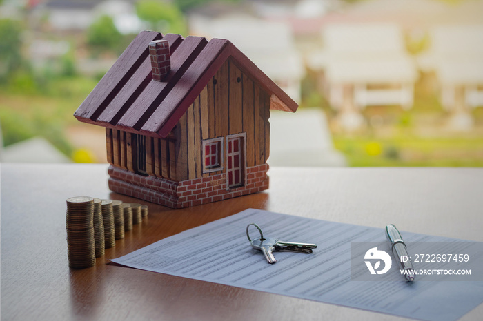 Home loan and Business investment concept. Closeup application form of Mortgage loans, pen, key, calculator and model wooden house with coins stack.