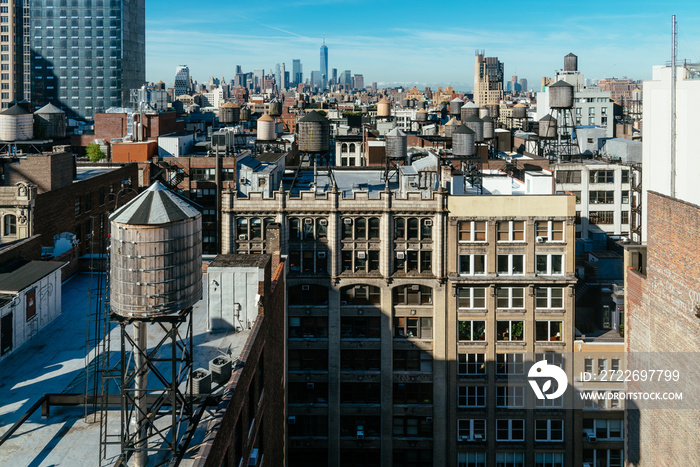 Skyline of Manhattan in New York City with water towers on the rooftops a sunny day with blue sky. Travel to New York