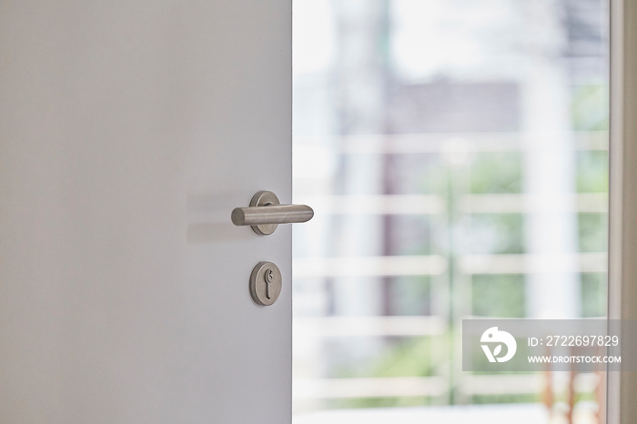 Door handle , door open in front of blur living interior room background, selective focus