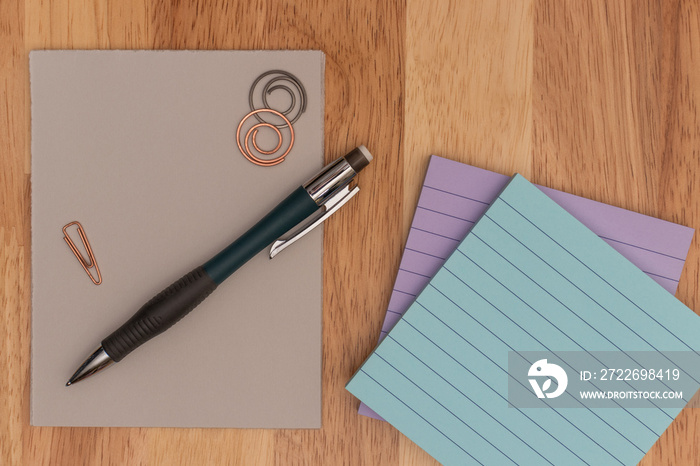 Administrative Professionals Day, Secretaries Day concept showing pencil, paper clips, and sticky notes on wooden surface