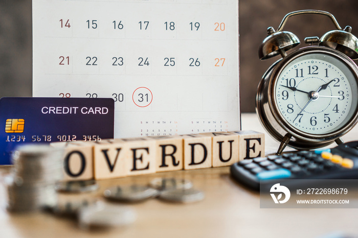 overdue bills concept with deadline calendar remind note,coins,credit card,calculator on table