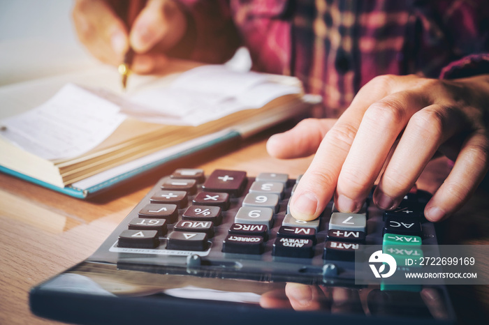 Businessman’s hands with calculator and cost at the office and Financial data analyzing counting on wood desk