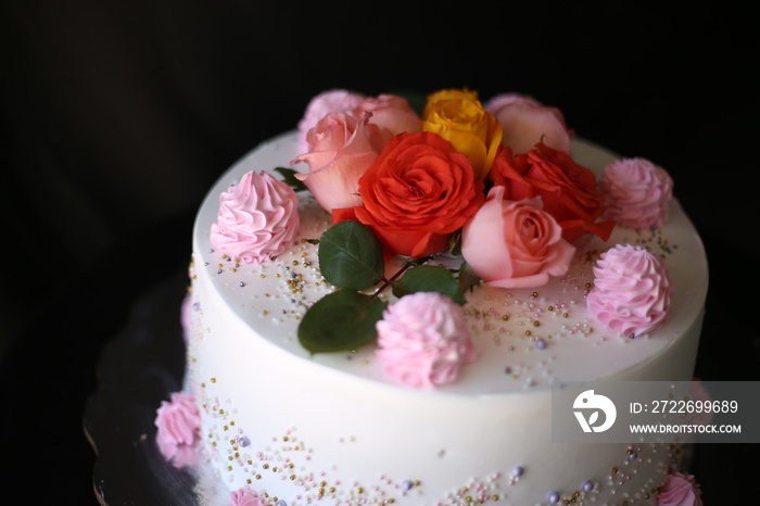 Luxury wedding table with a beautiful pink cake decorated with mastic pink rose and gold on black background