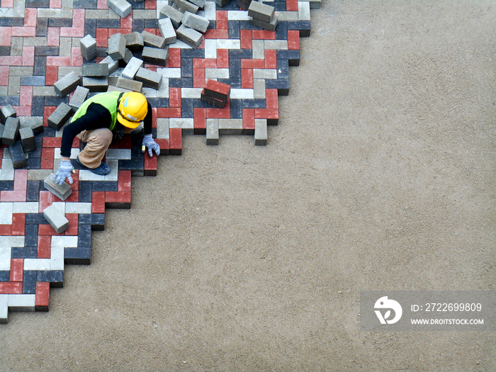 Construction workers installing  and arranging precast concrete pavers stone for road at the construction site.