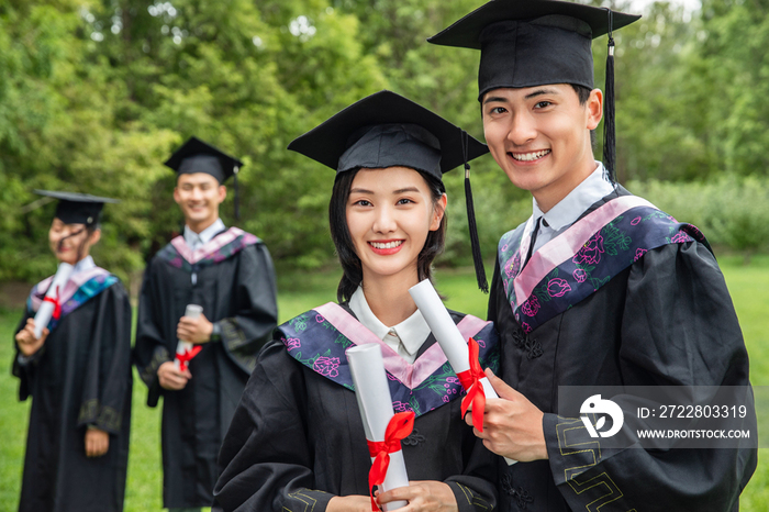 草地上穿着学士服的大学生们