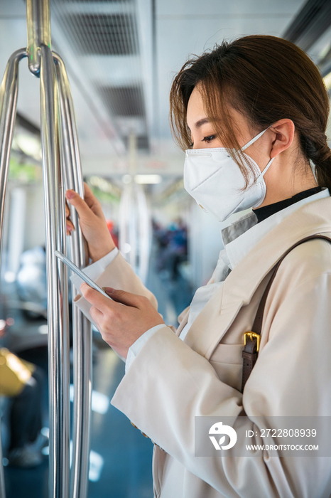 青年女人在地铁上看手机