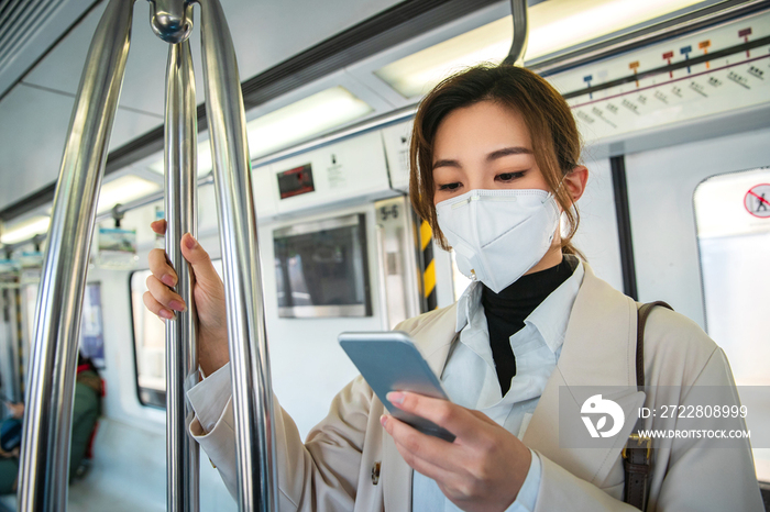 青年女人在地铁上看手机