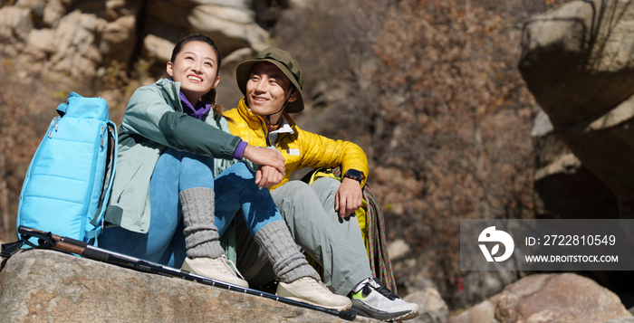 徒步旅行的青年伴侣坐在石头上休息