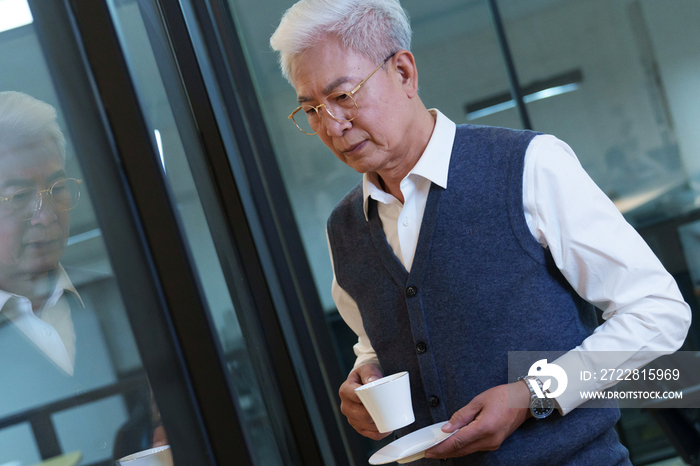 会议室内端着咖啡杯的商务老年男士