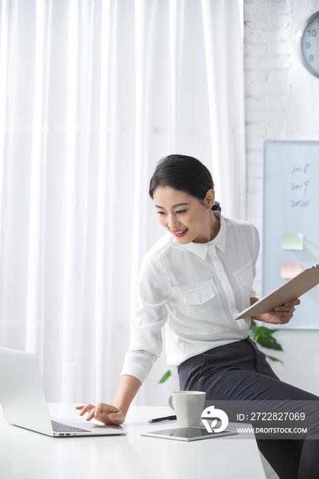 青年商务女人使用笔记本电脑办公