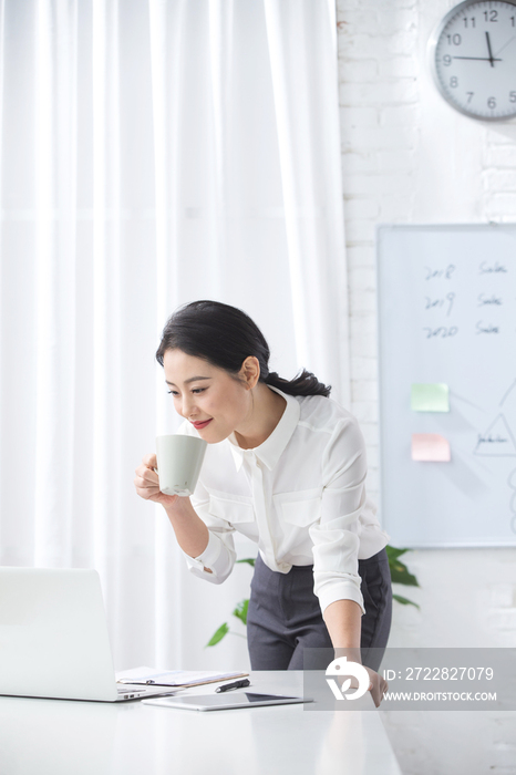 青年商务女人使用笔记本电脑办公