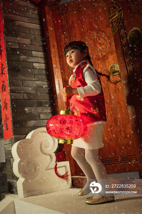 雪中小女孩手提红灯笼玩耍