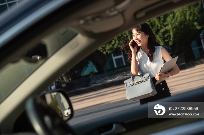 打电话的青年女人走向汽车