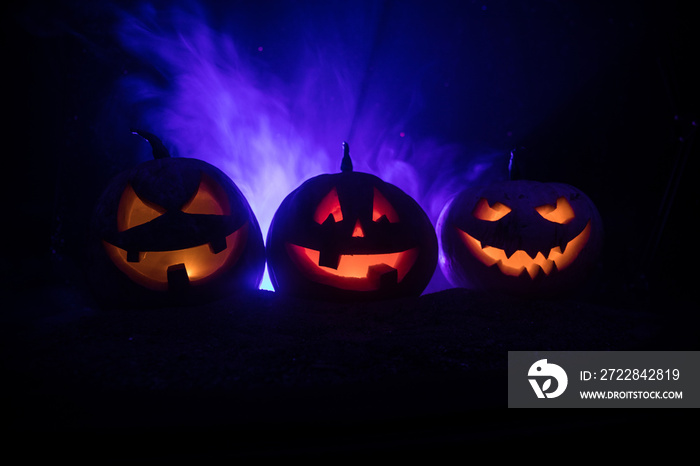 Group of Halloween Jack o Lanterns at night with a rustic dark foggy toned background