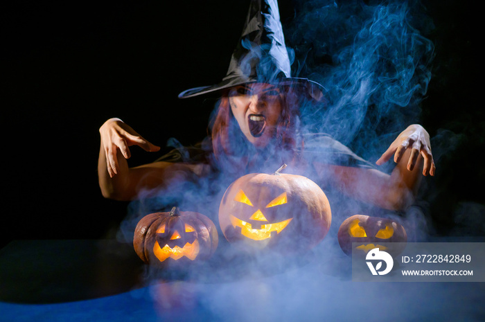 An ominous witch in a hat conjures over a jack-o-lantern. Traditional halloween characters. Mystical