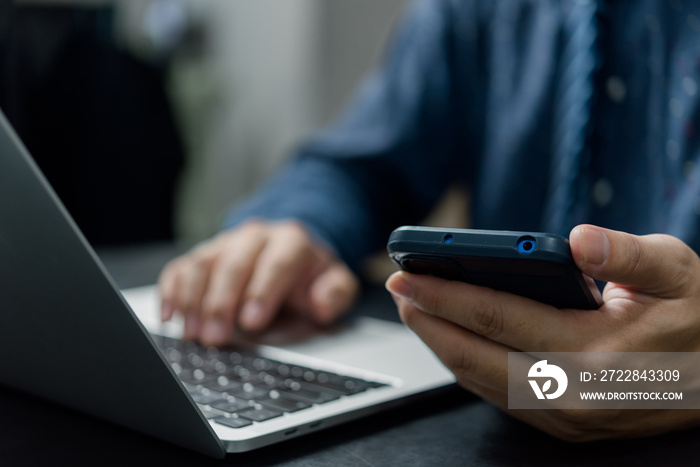 Man hand holding mobile smartphone digital technology network communications at desk.