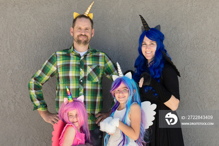 A family is dressed up in unicorn costumes complete with wings and wigs.