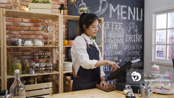 elegant smiling japanese shop assistant woman using pos point of sale terminal to put in order from 