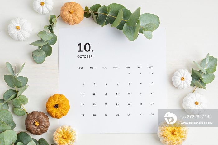 Flat lay with calendar for october with autumn table decoration.  Floral interior decor for fall hol