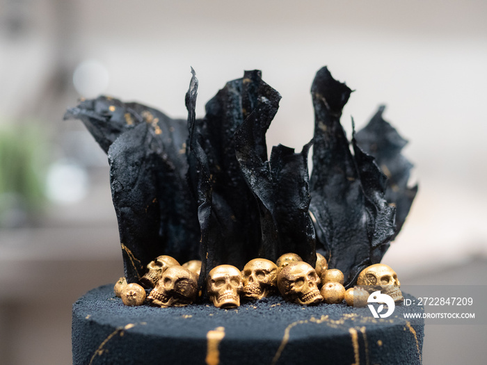 black matte textured frosted cup cake with golden chocolate skulls and black rice sails decoration