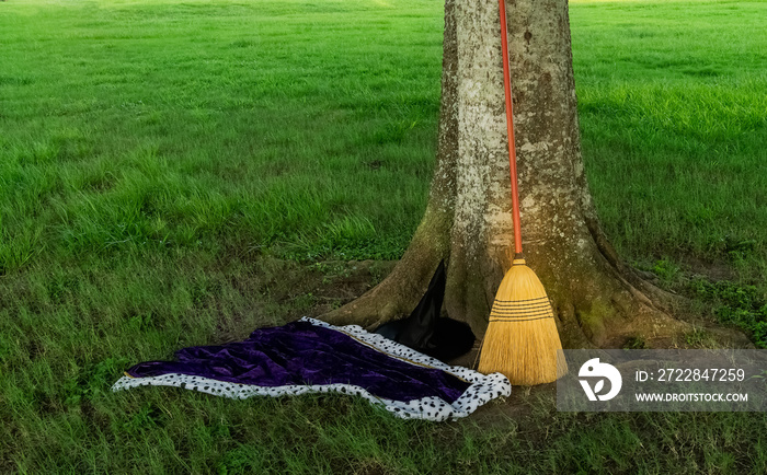 Witchs hat, cape and broom in a parking lot at a local park.