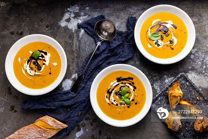 Pumpkin soup in a bowl with pumpkin seeds and croutons. fall dinner