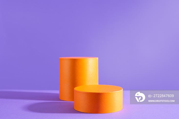 Halloween holiday concept. Orange Podiums or pedestals for products display on purple background.