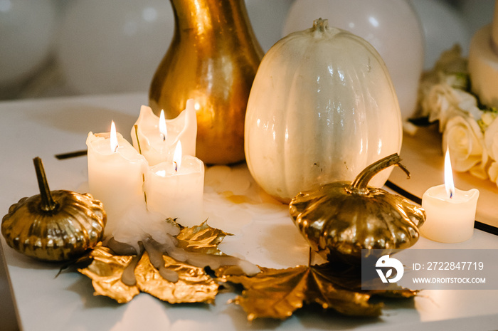 Decorated table for wedding. White balloons, candles, autumn leaves and small pumpkins. Autumn locat