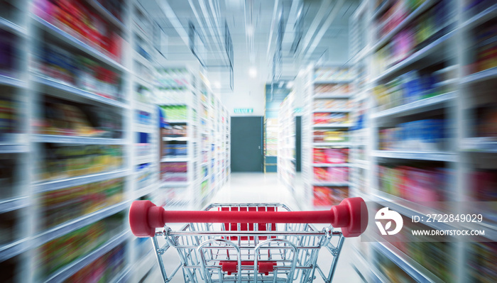 Red shopping cart with motion speed blurred .supermarket aisle background .