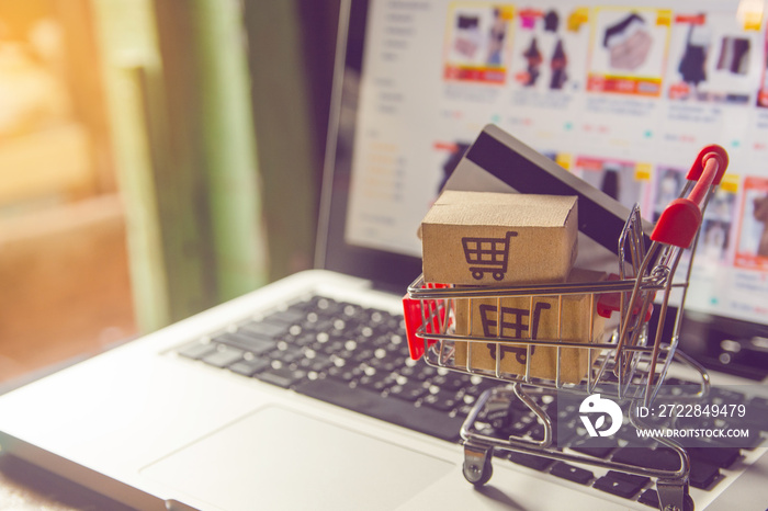 Shopping online. Credit card and cardboard box with a shopping cart logo in a trolley on laptop keyb