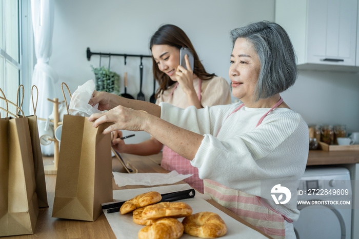 Asian happy family, senior mom and daughter cook food and sale at home