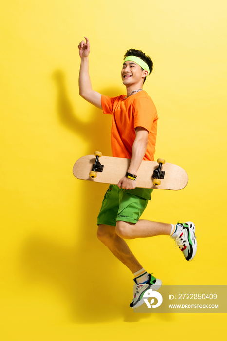 拿着滑板跳跃的活力青年男人