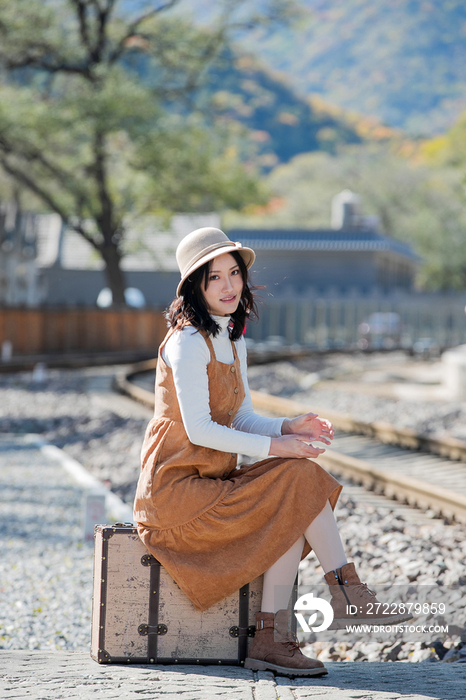 青年女人坐在铁轨上