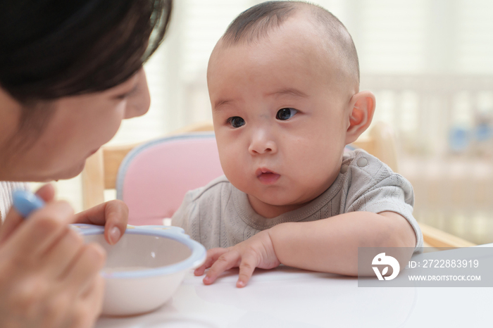 年轻妈妈喂宝宝吃饭