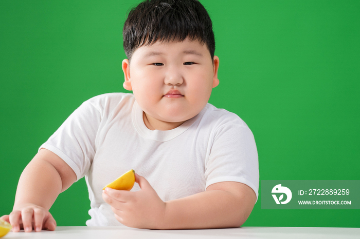 可爱的肥胖小男孩吃水果