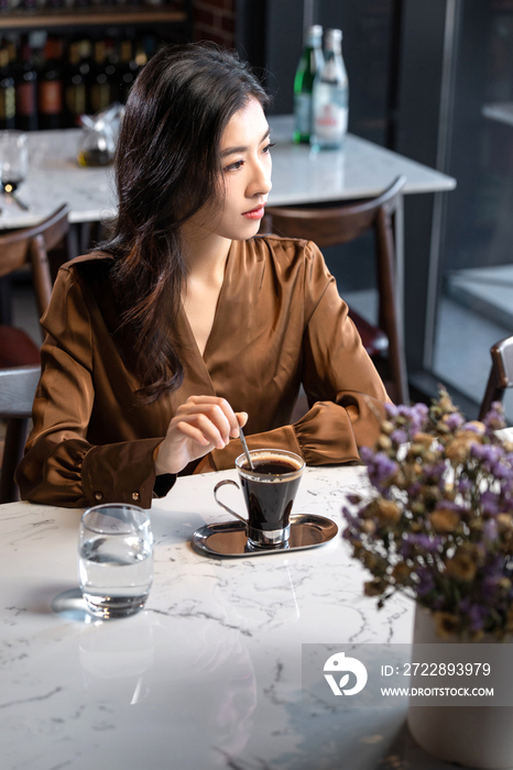 漂亮的青年女人喝咖啡