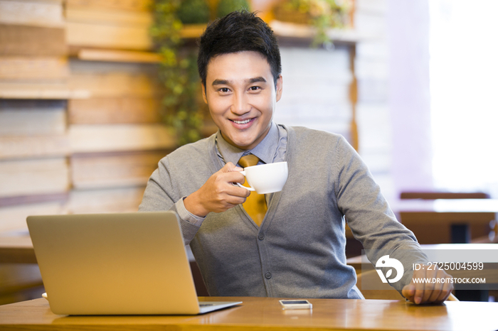 年轻男子在咖啡店喝咖啡上网
