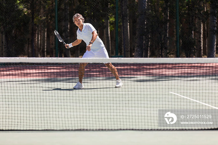 中老年男子在网球场打网球