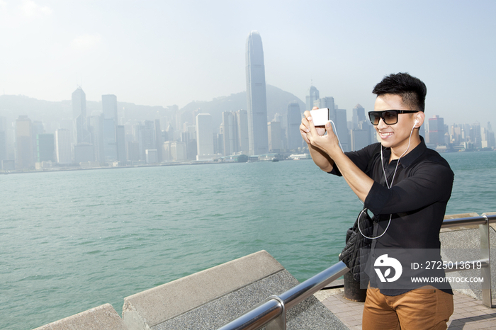 年轻男子在香港用手机拍照