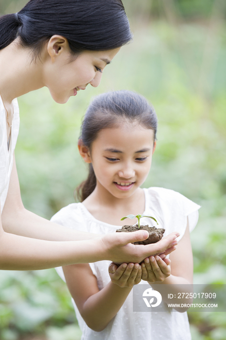 年轻妈妈给女儿一株幼苗