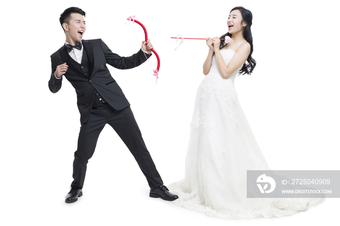 快乐的新娘和新郎拿着弓箭
