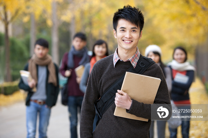 校园林荫道上的男性大学生和朋友们