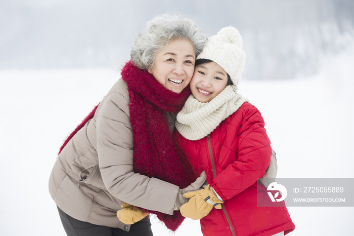 快乐的奶奶和孙女在雪地上拥抱