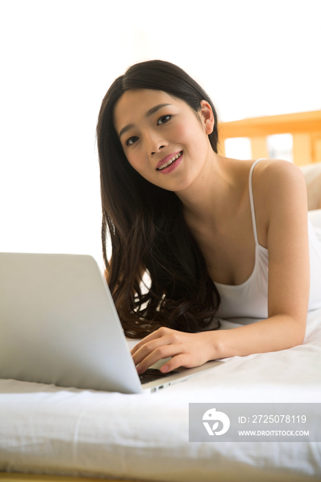 青年女人在卧室使用电脑