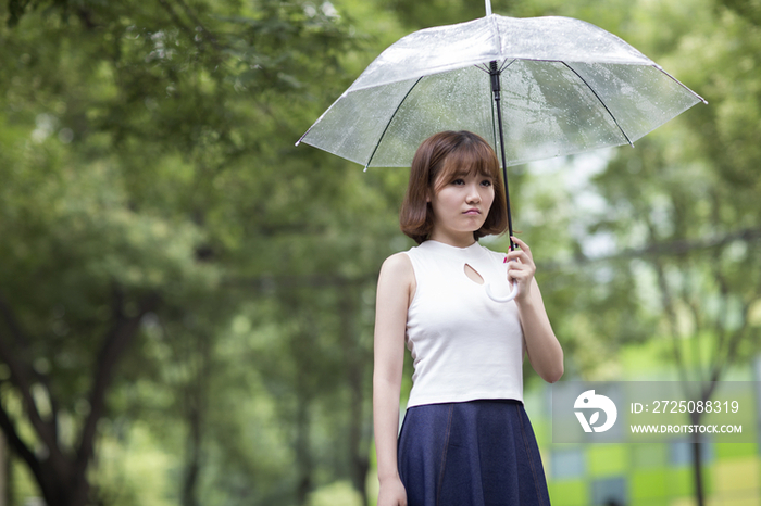 闷闷不乐的年轻女子打着雨伞